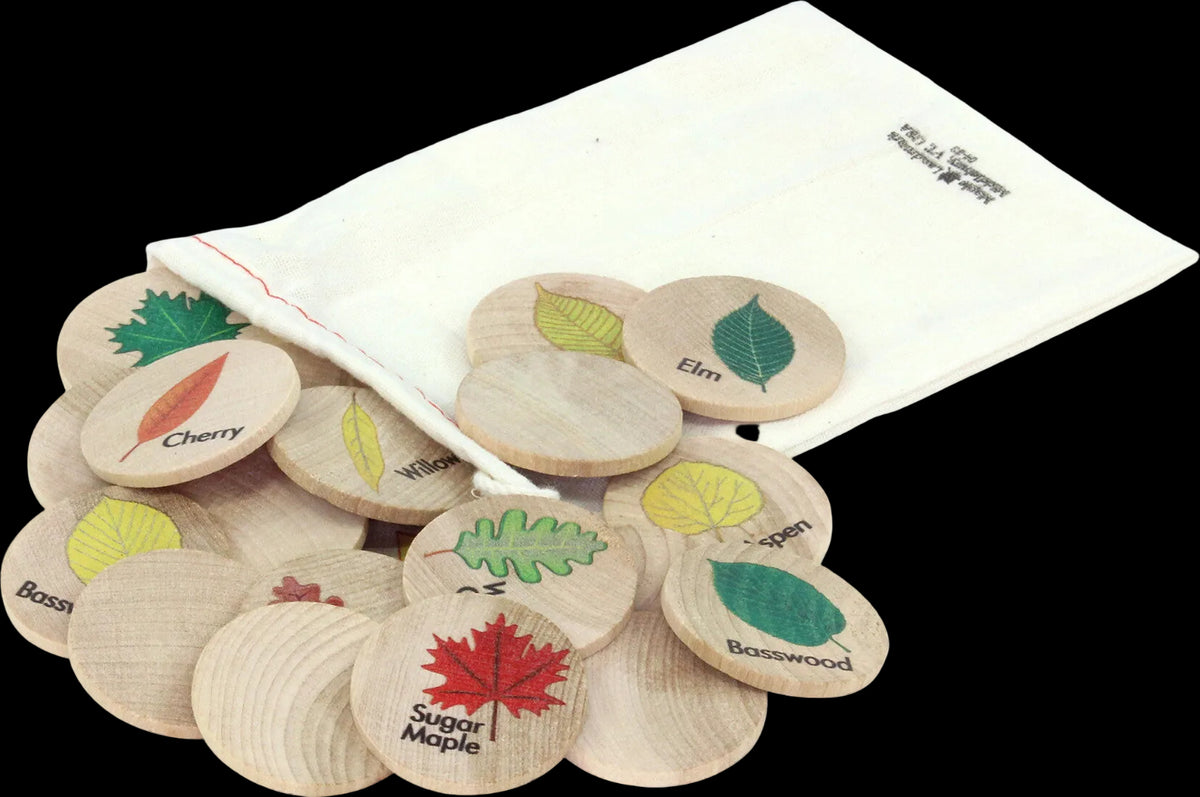 Wooden educational sorting tokens with colorful leaf illustrations and labels, shown with a white fabric pouch on a white background.